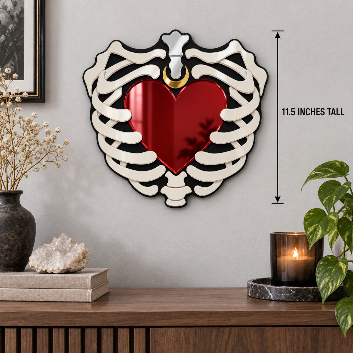 Heart-shaped wall mirror with a white rib cage border and a red reflective center, mounted on a light gray wall above a wooden console. A black measurement arrow on the right reads 11.