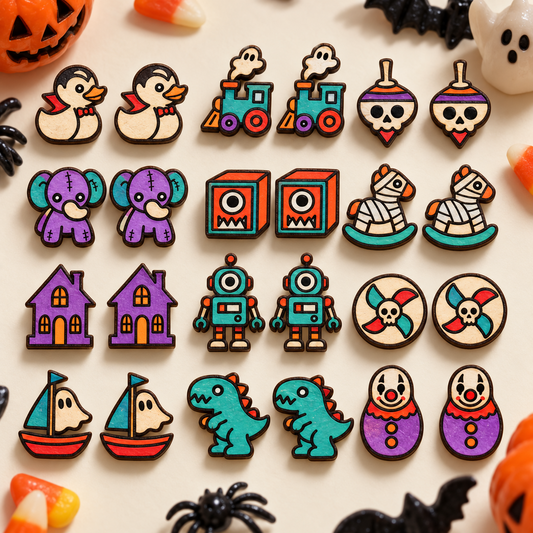 Colorful Cursed Toybox horror stud earrings arranged in a Halloween flat lay