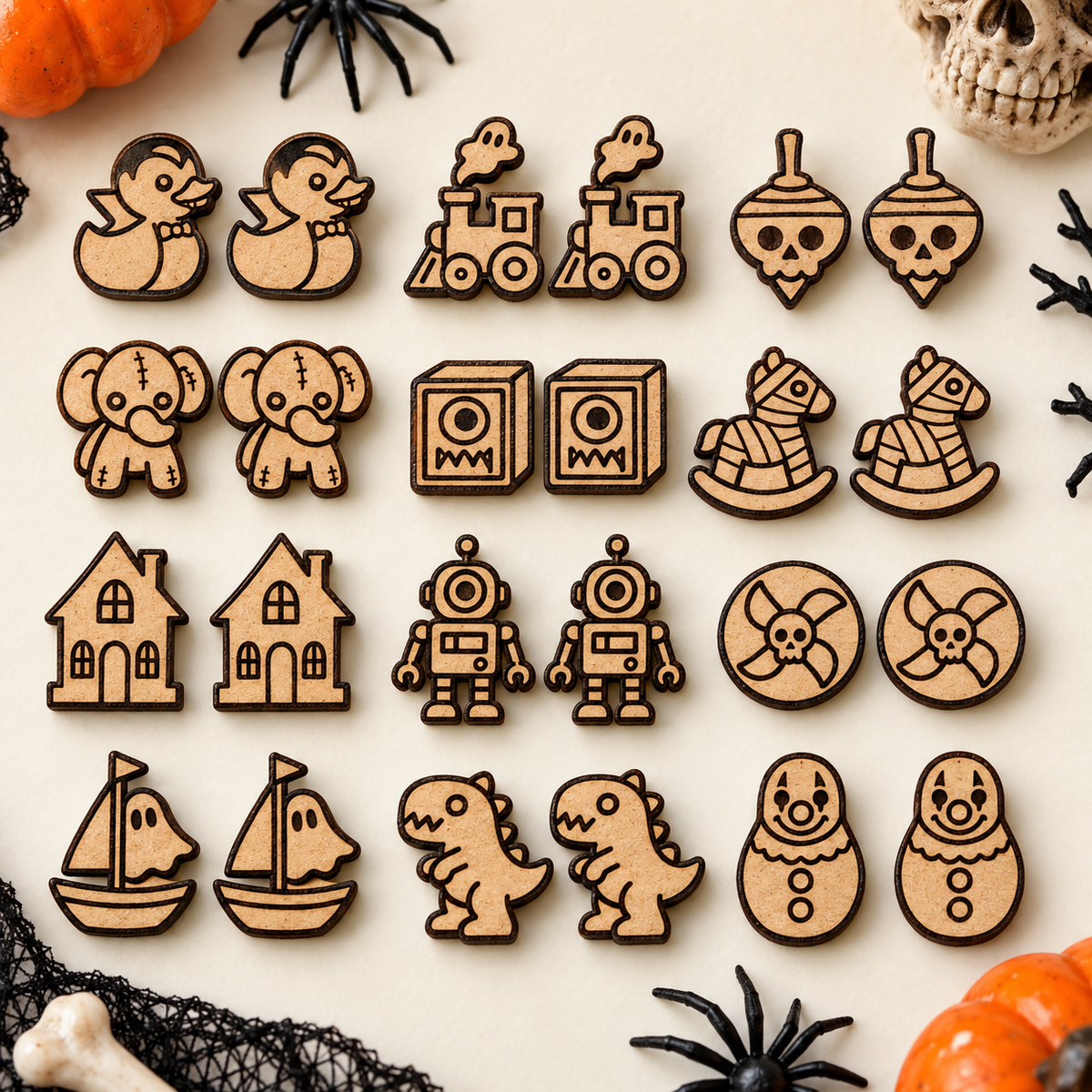 Unpainted MDF mockup of twelve Cursed Toybox horror stud earring SVG designs