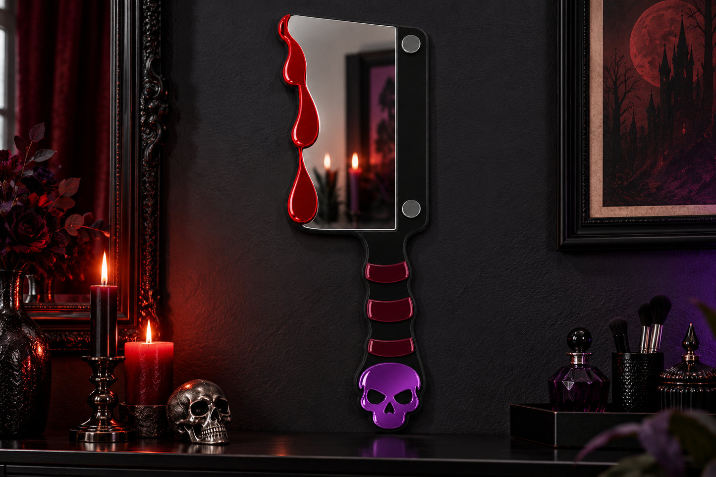 A gothic-style decorative wall mirror shaped like a cleaver, featuring a black blade with red dripping accents, a black handle with red stripes, and a purple skull at the end, displayed on a dark shelf in a moody room with candles and framed artwork.
