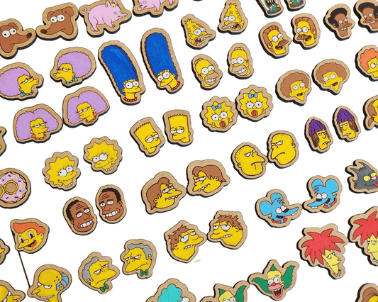 A collection of various Simpson's character-themed earrings laid out on a surface.